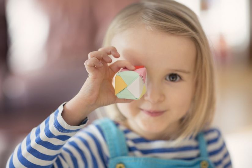 child holding origami box