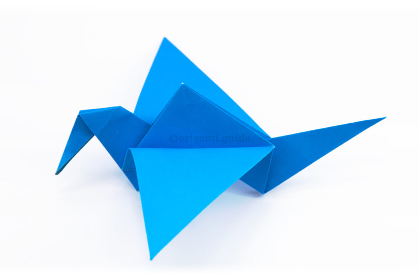 31. Fold the wings down a little, then tug on the tail gently, outwards away from the head.