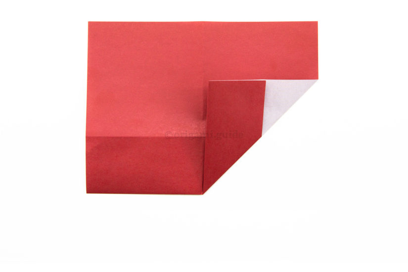 9. Fold the bottom right corner diagonally up to the left, aligning it with the vertical crease.