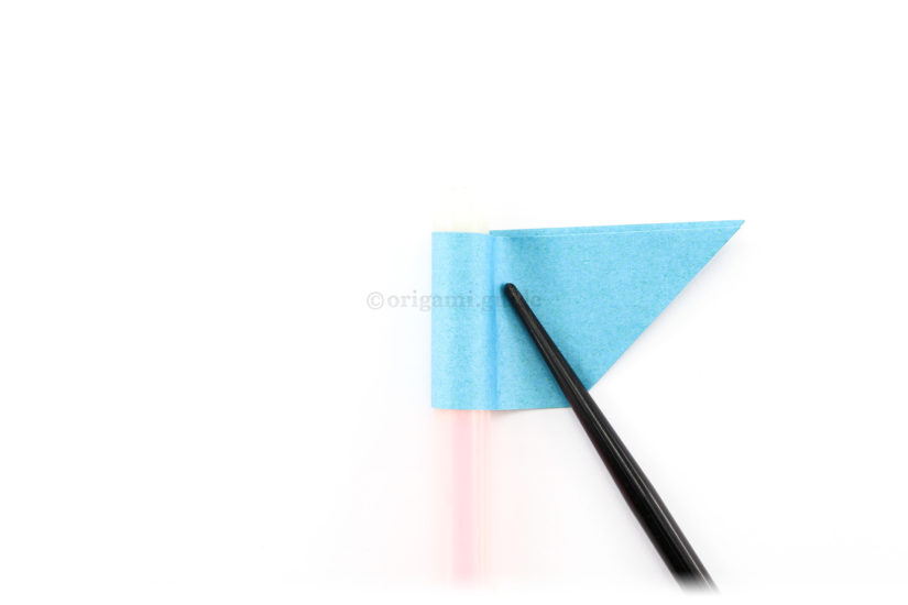 15. Fold the left end over your finger or pen and to the right. Shape the paper around to create a tube.