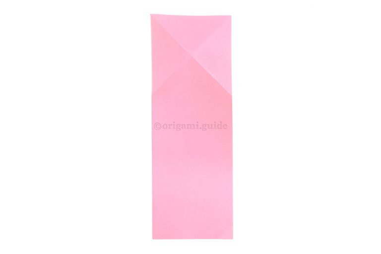 Unfold the previous step and flip the paper over to the other side.