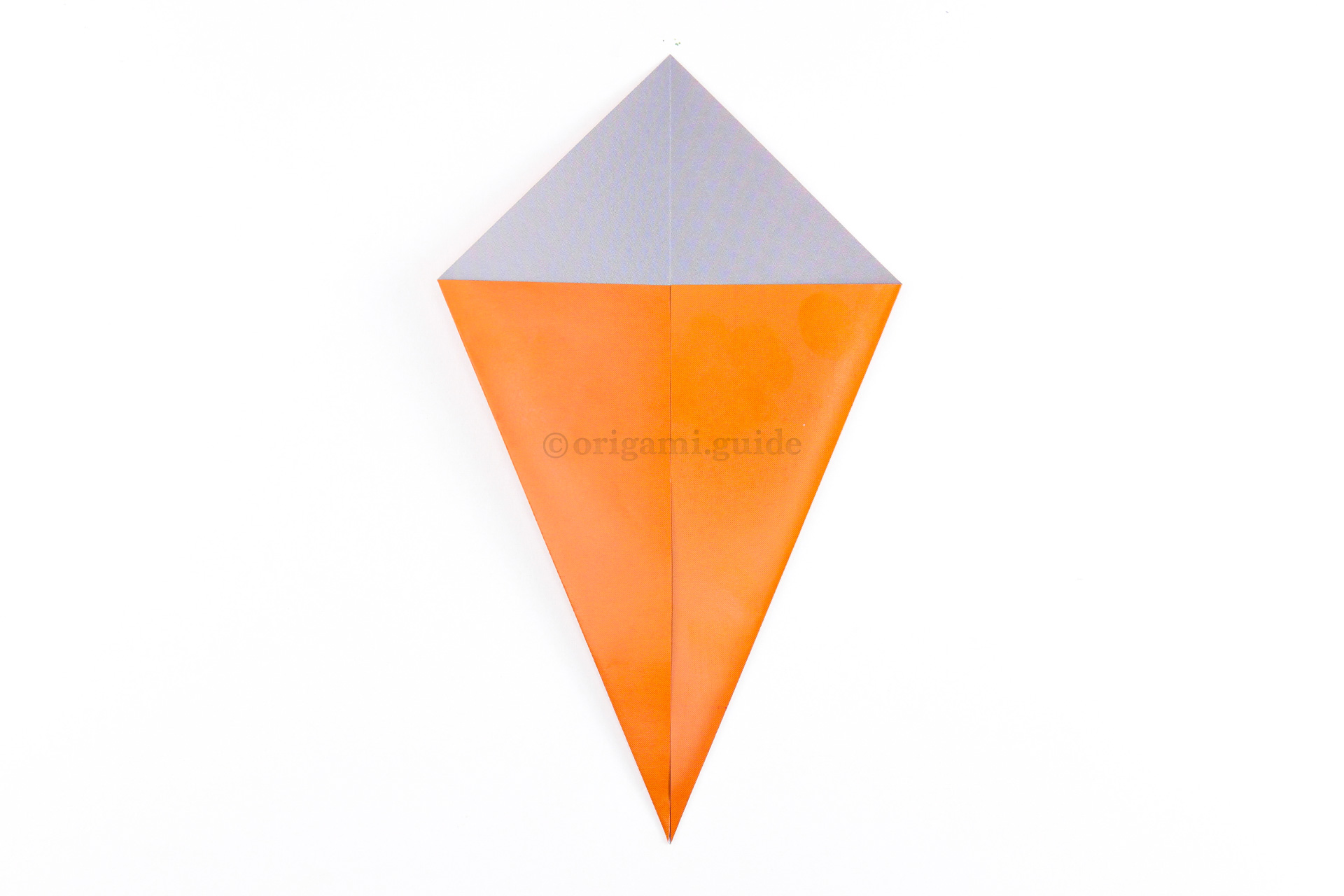 Fold the left and right points diagonally to the centre to make a Kite shape.