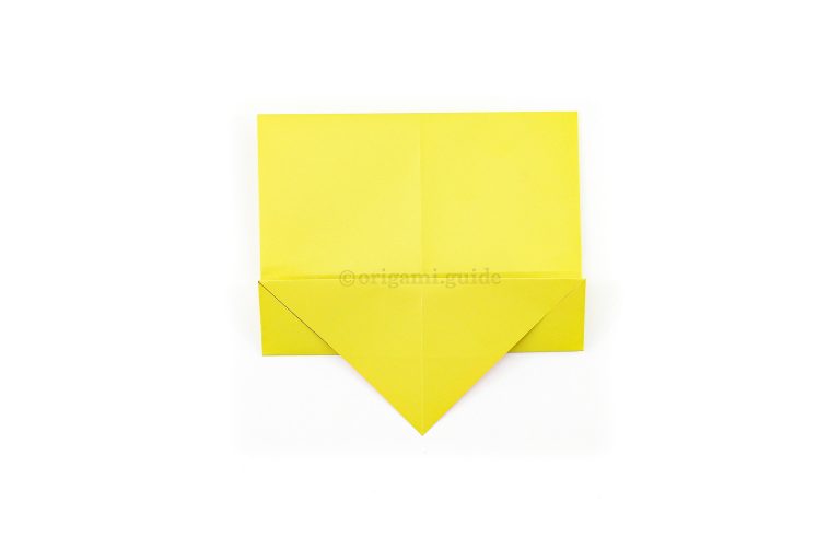 Fold the bottom edge to the center, allowing the bottom triangular flap to come to the front.