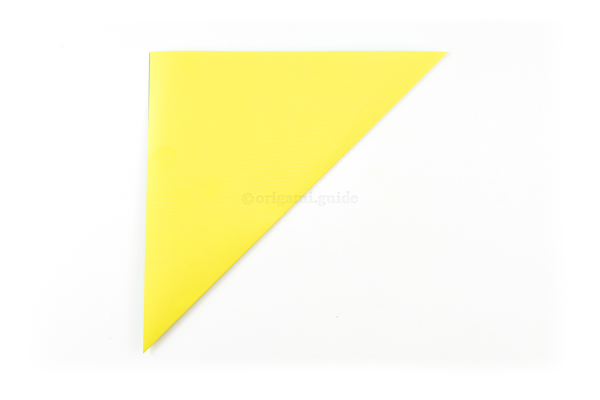 Start by making an origami square base. Fold the bottom right corner diagonally up to the top left corner.