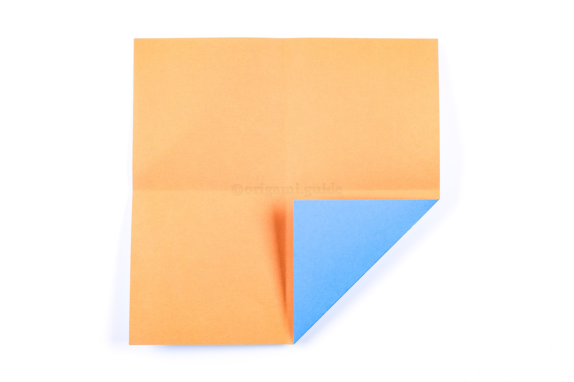 Using the creases as guidelines, fold one of the corner to the middle, leaving a small gap.
