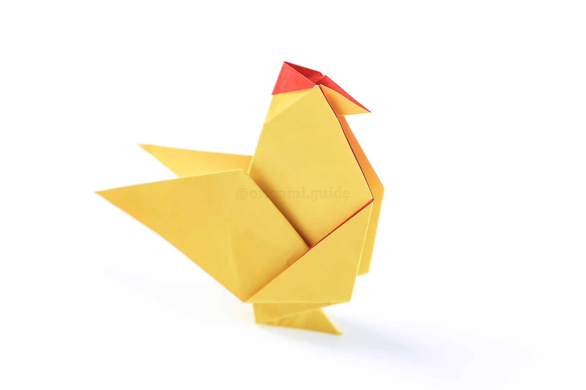 The origami chicken is complete! If your chicken won't stand up, try pulling the leg folds to be more angled and open it's wings a little.