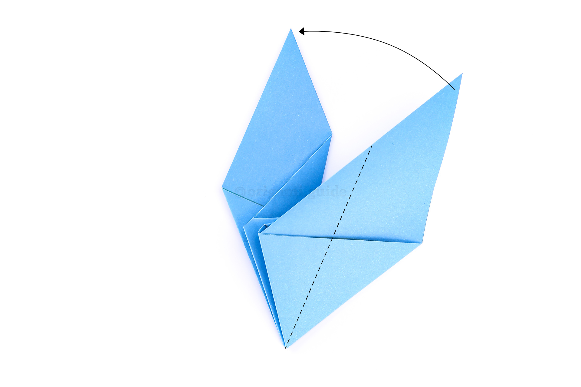 Flip the paper over again. Next fold the front-most wing diagonally to match the wing underneath.