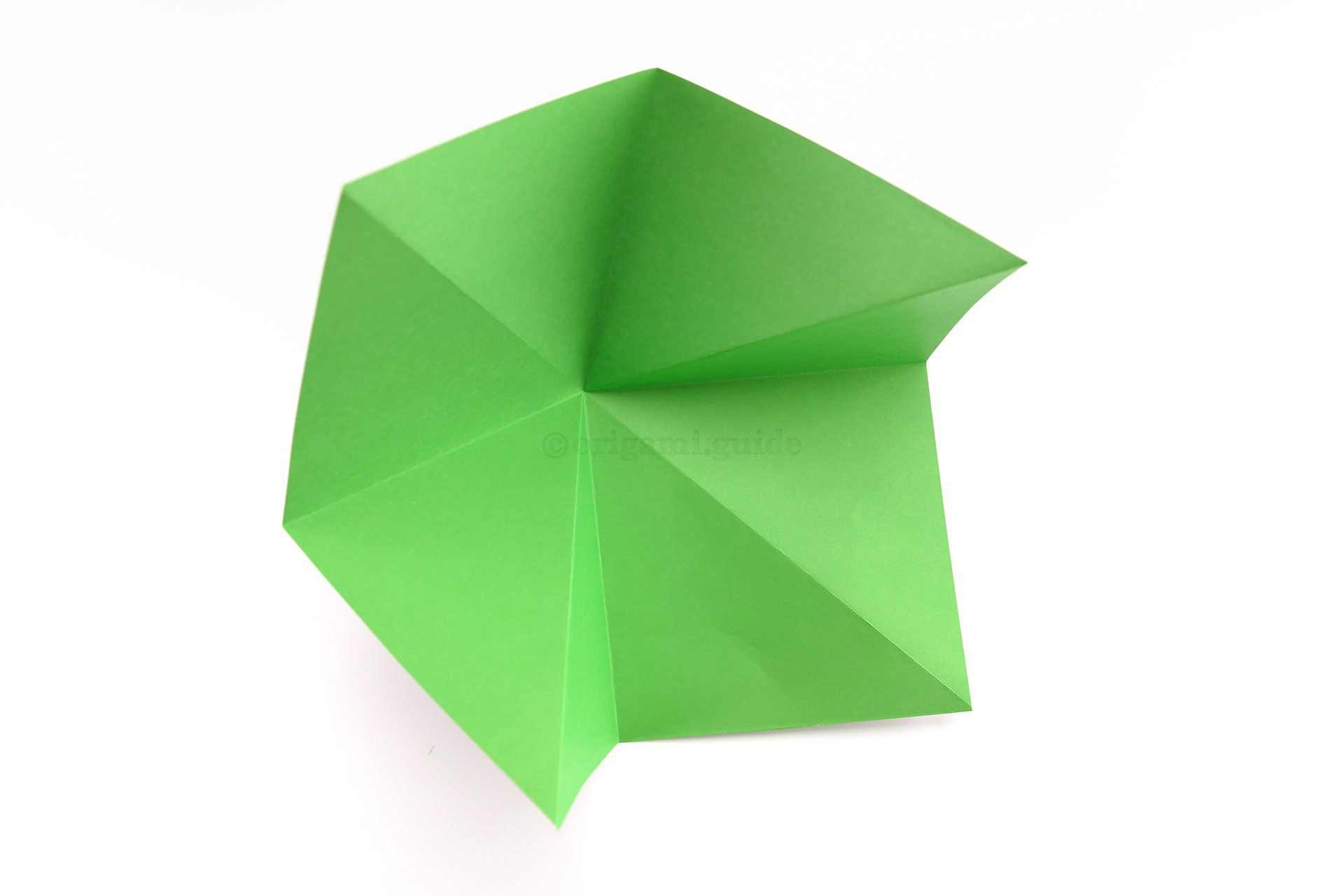 Begin folding the corners of the paper inwards.